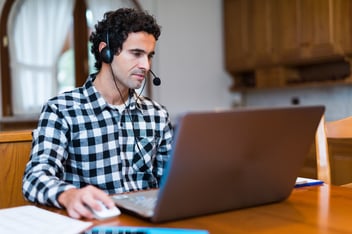 Man in plaid shirt on computer with microphone-1