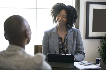 Woman in businesswear presenting to employee in office-1