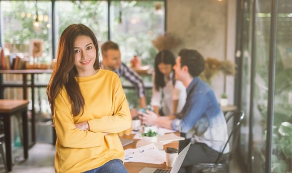 Woman in yellow sweater sitting on table