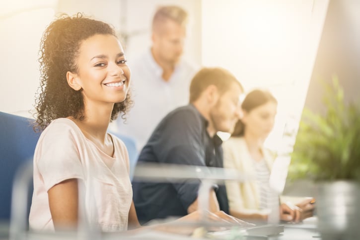 Woman smiling at computer wearing tshirt