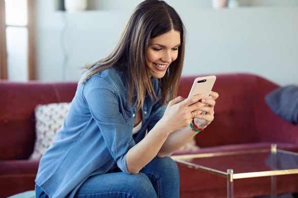 Woman smiling looking at phone texting-1