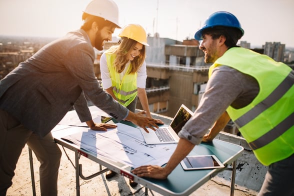 employees looking at computer on construction site-1