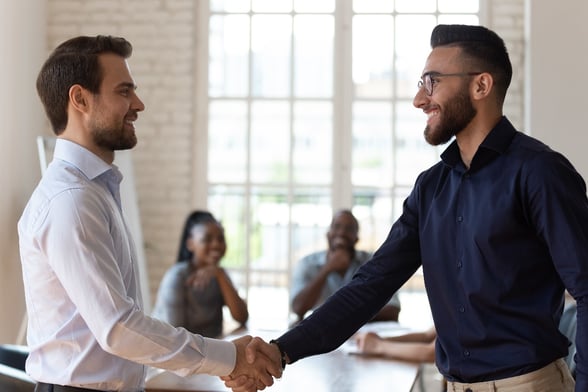 two office men shaking hands greeting each other